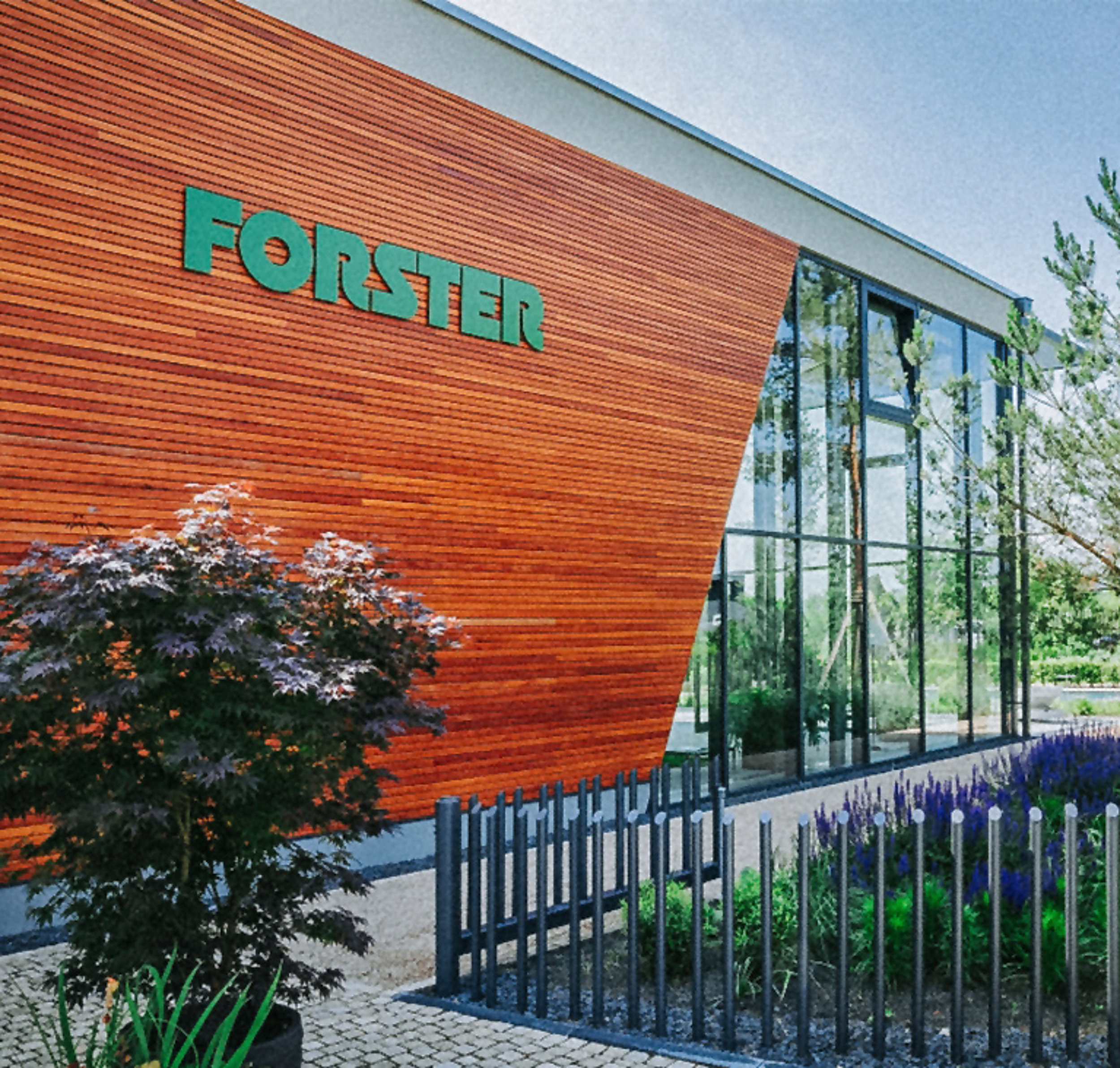 Außenfassade der Forster-Gebäudes aus Holz mit Logo. 