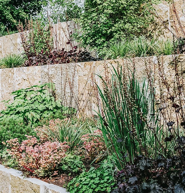 Privatgarten mit bepflanzten Beeten aus Krustenplatten 