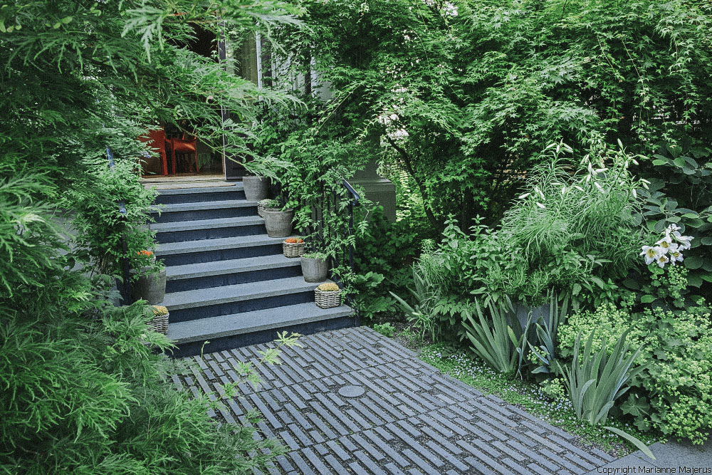 Eine Steintreppe mit besonders gepflastertem Gartenweg führt in einen Familiengarten in Koblenz