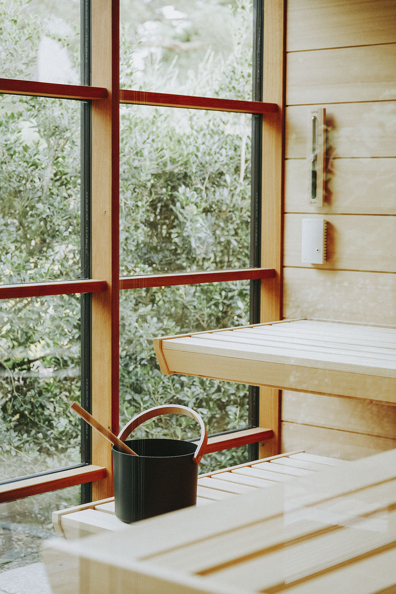 Gartensauna aus Holz mit Schwebebänken, Glasfront und Saunaeimer 